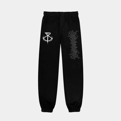 Brand of Sacrifice black sweatpants with an elastic waistband and cuffs, bold white abstract logo on the left thigh, and vertical graphic design down the right leg.